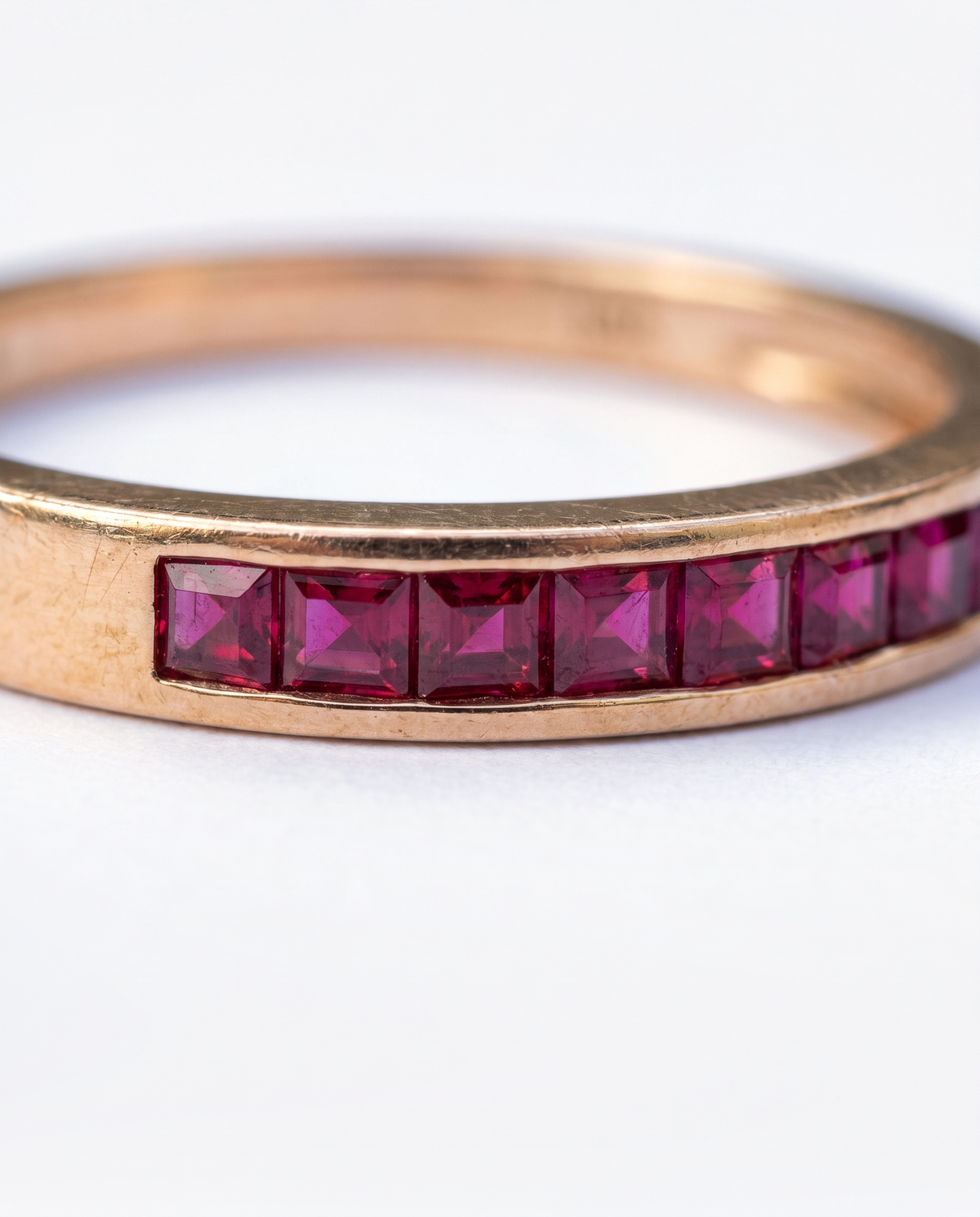 Ruby Channel, 18K yellow gold ring set with rubies, macro close-up of the ruby setting along the band